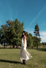 Vestido largo color crema con estampado geométrico lineal en negro, escote en V, breteles finos ajustables y bolsillos laterales.