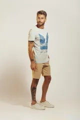 Remera de algodón con estampado frontal en tonos beige y azul, de corte clásico y manga corta.