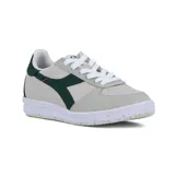 Championes casuales unisex Diadora modelo B.Elite ACBC, con capellada en tonos beige claro y gris claro, y detalles en verde oscuro en el logo lateral y talón. Suela blanca con motas de color reciclado.