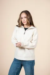 Cardigan color crudo de tejido de punto acanalado, con cuello alto y cierre frontal parcial con cremallera metálica. De corte oversize, mangas largas y puños ajustados.