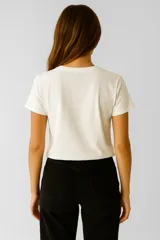 Remera color crema de algodón con cuello redondo y estampado con la frase "In my inner peace era" en letras negras.