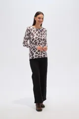 Sweater de tejido de punto, color crema, con estampado floral en tonos rosados y marrones. Presenta cuello redondo y mangas largas.