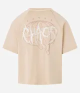 Remera de algodón color beige claro, corte boxy, con cuello redondo y mangas cortas. Presenta un estampado frontal en blanco con la palabra "Chaos" en tipografía estilizada.
