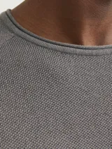 Sweater gris de punto con cuello redondo y mangas largas.