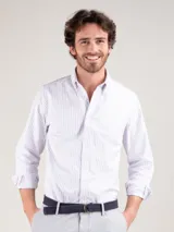 Camisa de hombre a rayas verticales blancas y celestes, corte regular fit, cuello button-down, cierre con botones, manga larga con puño simple y logo bordado en el pecho.