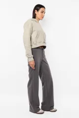 Buzo crop de frisa gamuzada color beige. Diseño con bolsillo canguro delantero, capucha con forrería interna, ojalillos metálicos de marca, cordón ajustable con punteras metálicas, puños y cintura en rib.