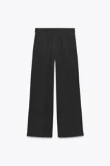 Pantalón negro de tiro alto con cintura elástica, bolsillos delanteros y detalle de banda lateral blanca.