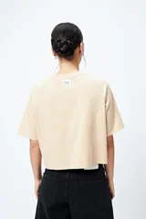 Remera cropped blanca de mangas ranglan con estampa frontal de un auto antiguo y texto "Vintage Gems / retro car club".