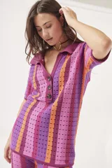 Sweater de tejido crochet a rayas verticales en tonos azul, verde, marrón y blanco, con cuello polo y cierre de botones.