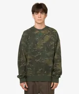 Buzo de cuello redondo, manga larga, color verde oliva con estampado abstracto tipo camuflaje o manchas en tonos verdes más claros y oscuros. Presenta puños y cintura acanalados en color verde liso.