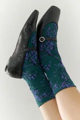 Medias de vestir color verde oscuro con estampado floral en color lila.