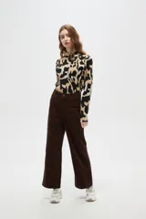 Pantalón de algodón color beige, de tiro alto, corte ancho y largo, con bolsillos frontales tipo parche.