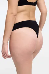 Conjunto de ropa interior blanco, compuesto por un corpiño de breteles finos y una bombacha tipo colaless con detalles de puntilla.