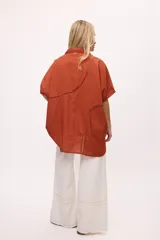 Camisa blanca de manga corta con cuello clásico, corte holgado y detalle de calado vertical en el frente.