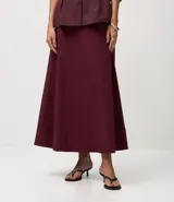 Pollera midi evasé color vino tinto, confeccionada en bengalina. Presenta un recorte horizontal en la parte delantera.