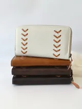 Billetera grande de cuero color marrón con cierre metálico y detalle de costuras en forma de espiga. Incluye monedero interno y espacio para billetes extendidos.