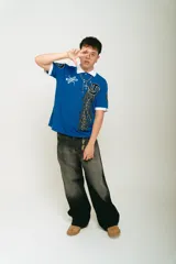 Chomba azul de piqué con cuello blanco, corte regular, manga corta con puños blancos, estampado con logo en la manga y bordado en el pecho.