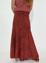 Pollera larga de jean color terracota, corte acampanado y diseño con paneles.