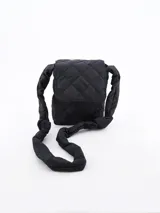 Morral negro acolchado con diseño de rombos y correa de hombro gruesa con nudos.