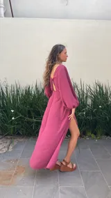 Vestido largo color borgoña, con escote en V, mangas largas abullonadas y falda con volados. Presenta un corte en la cintura con detalle de nudo.