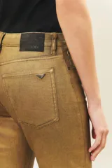 Jean slim color dorado metalizado, de tiro medio y largo al tobillo.