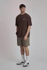 Remera marrón de corte holgado con estampado pequeño en el pecho.