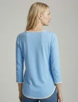 Remera de manga tres cuartos color celeste, confeccionada en modal con elastano. Presenta un aplique de bordado blanco en el escote redondo y en los puños.