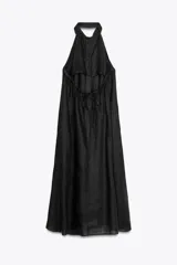 Vestido midi negro de lino, con cuello halter, hombros descubiertos, espalda descubierta, cierre frontal con botones y bajo asimétrico.