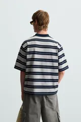 Polo de hombre corte holgado con cuello solapa y cierre de botones. Diseño a rayas horizontales grises y azul marino.