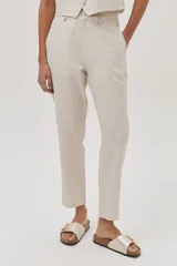 Pantalón chino de lino metalizado color beige, tiro medio-alto y pierna recta. Cuenta con bolsillos laterales y traseros.