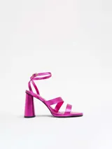 Sandalias de tacón alto color fucsia, con tiras finas cruzadas sobre el empeine y pulsera al tobillo.