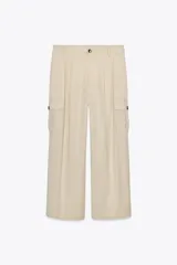 Pantalón color beige de tiro alto con bolsillos delanteros, bolsillos de plastrón con solapa laterales y falsos bolsillos de vivo en la espalda. Bajo acabado con trabilla y botón. Cierre frontal con cremallera y botón.
