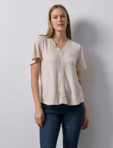 Remera color beige en tejido melange, con escote en V y aplique de crochet en el frente.
