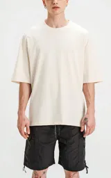 Remerón color beige de corte crop y calce oversize, con hombros caídos y cuello redondo.