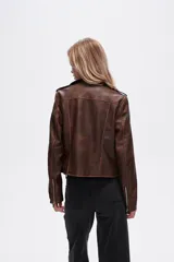 Chaqueta marrón de eco-cuero, corte recto, con cierre asimétrico y cuello solapa.