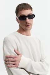 Buzo de punto color crudo, de corte oversize, con cuello redondo y puños.