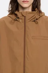 Gabardina corta color verde oliva de tejido técnico con corte en línea A, cuello alto, capucha ajustable, manga larga con puños ajustables, cierre frontal con cremallera y logo estampado.
