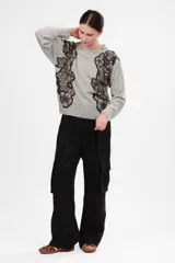 Sweater gris de cashmere y lana con estampado floral en negro y beige en los hombros.