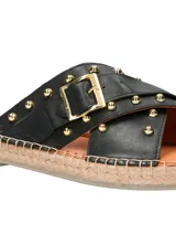 Sandalia de cuero negro con tiras cruzadas y hebilla dorada. Plataforma de yute.