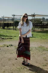 Pollera midi tejida en hilado 100% algodón, color marrón con rayas horizontales en tonos rojo y verde.