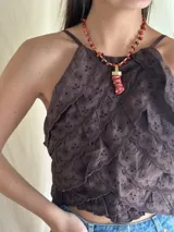 Collar corto con cuentas de coral rojo y detalles de bronce. Incluye un dije con forma de cuerno de la abundancia.
