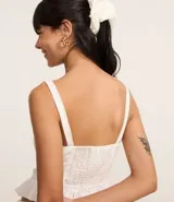 Blusa corset de laise blanca con bordado de flores, escote cuadrado, breteles y volados en el ruedo. Cierre frontal con corchetes.