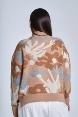 Sweater de punto con cuello alto, estampado floral en tonos gris, marrón, beige y fucsia.