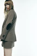 Blazer de cuello solapa y manga larga con estampado de pata de gallo en tonos marrones y negros. Bolsillos de vivo en delantero, detalle de coderas a contraste y cierre frontal con botón.
