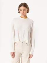 Sweater tejido suave y flojo, color crudo, con cuello redondo y mangas largas.