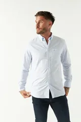 Camisa oxford celeste con rayas verticales blancas, de manga larga y corte regular. Tiene cuello abotonado, bolsillo en el pecho y logo bordado.