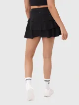 Falda corta deportiva negra con calza incorporada y tablas plisadas.