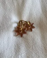 Par de aros dorados con dije de estrella de acrílico color rosa.
