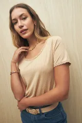 Remera color beige de manga corta y cuello redondo con puntilla en mangas y escote.