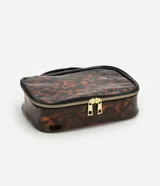 Neceser rectangular grande de plástico transparente con estampado de carey en tonos marrones. Tiene cierre de cremallera doble dorada, asa de mano negra y ribete negro.